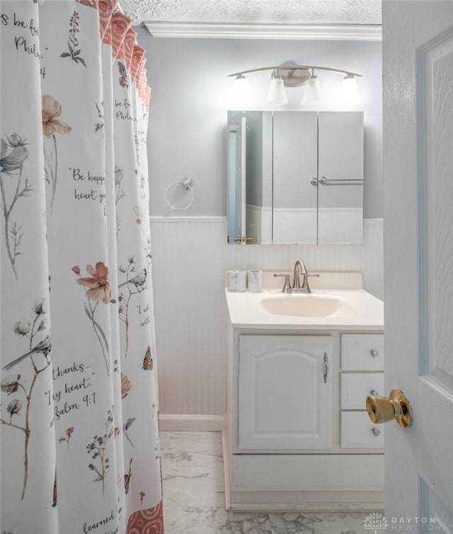 bathroom with a wainscoted wall, marble finish floor, and vanity