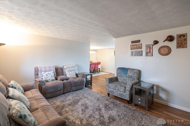 living room with baseboards, wood finished floors, and a textured ceiling