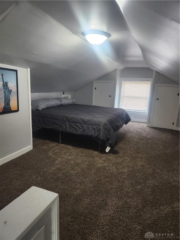 bedroom featuring carpet, vaulted ceiling, and baseboards