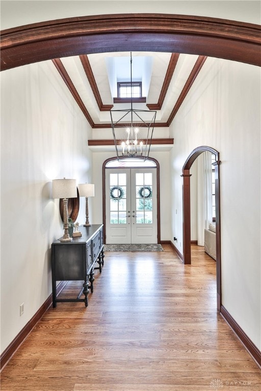 7177 Paul Ln, Liberty Twp, OH 45044 - foyer featuring light wood finished floors, a chandelier, crown molding, arched walkways, and french doors