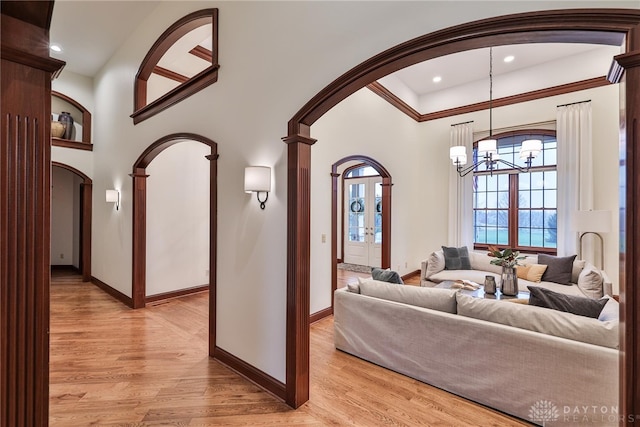 7177 Paul Ln, Liberty Twp, OH 45044 - living area featuring a chandelier, baseboards, arched walkways, and light wood-style flooring