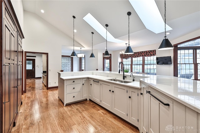 7177 Paul Ln, Liberty Twp, OH 45044 - kitchen featuring a sink, light wood-style flooring, light countertops, a skylight, and hanging light fixtures