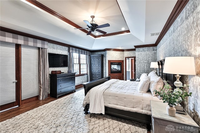 7177 Paul Ln, Liberty Twp, OH 45044 - bedroom with wood finished floors, wallpapered walls, visible vents, a raised ceiling, and crown molding
