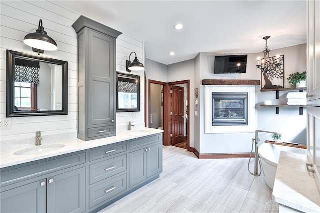 7177 Paul Ln, Liberty Twp, OH 45044 - full bathroom with double vanity, a chandelier, a freestanding bath, and a sink