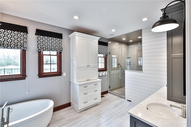 7177 Paul Ln, Liberty Twp, OH 45044 - bathroom featuring a soaking tub, a sink, double vanity, a stall shower, and baseboards