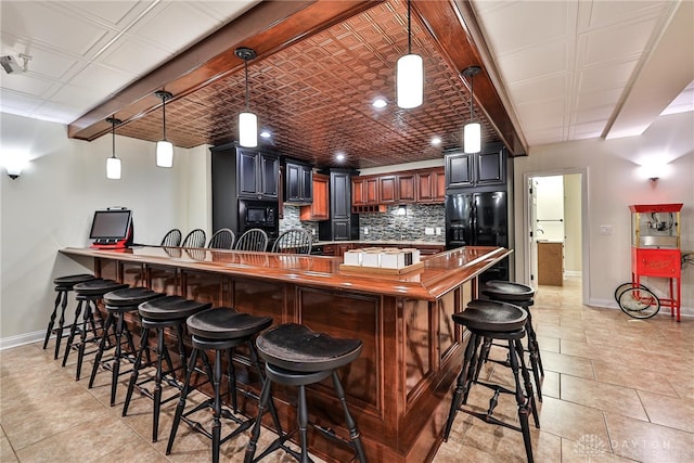 7177 Paul Ln, Liberty Twp, OH 45044 - kitchen featuring black appliances, a breakfast bar area, backsplash, and baseboards