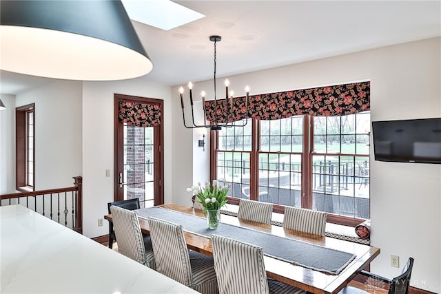 7177 Paul Ln, Liberty Twp, OH 45044 - dining area with wood finished floors, baseboards, a notable chandelier, and a skylight