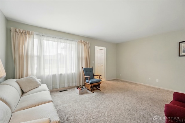 carpeted living area featuring visible vents and baseboards