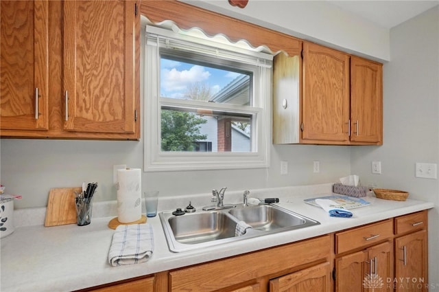 kitchen with brown cabinets, light countertops, and a sink