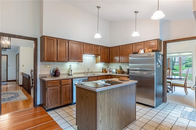 9168 Woodstream Ln, Washington Twp, OH 45458 - kitchen with appliances with stainless steel finishes, high vaulted ceiling, light tile patterned floors, tasteful backsplash, and brown cabinets