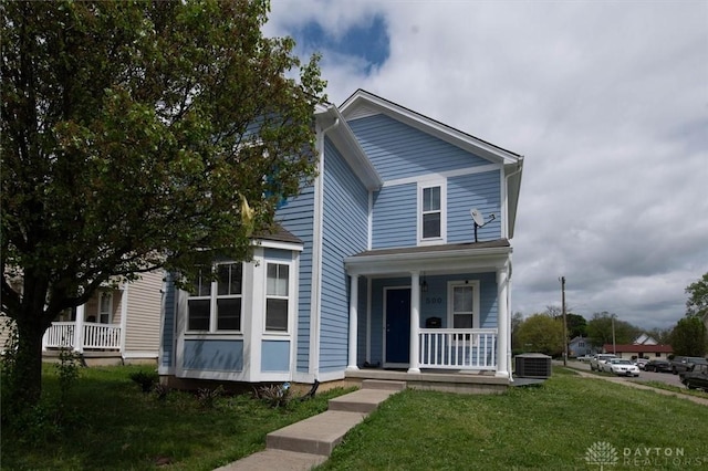 traditional-style home featuring central AC, a porch, and a front yard
