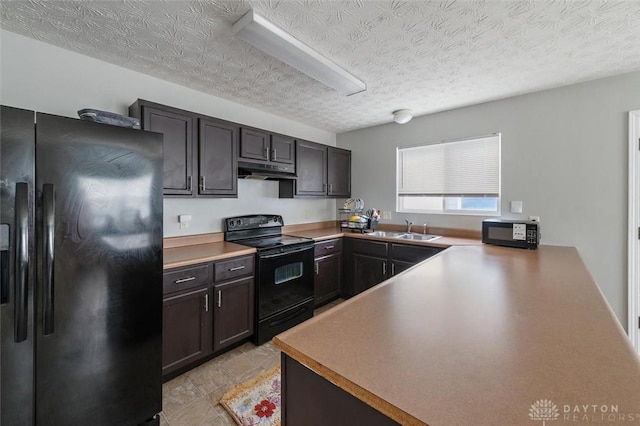 kitchen with black appliances, a textured ceiling, a sink, and under cabinet range hood