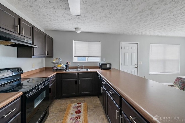 kitchen featuring black appliances, a sink, a textured ceiling, and under cabinet range hood
