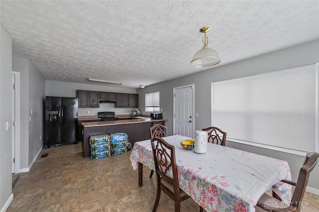 dining space with baseboards and a textured ceiling