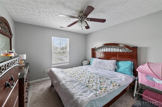 bedroom featuring a ceiling fan, visible vents, baseboards, a textured ceiling, and carpet floors