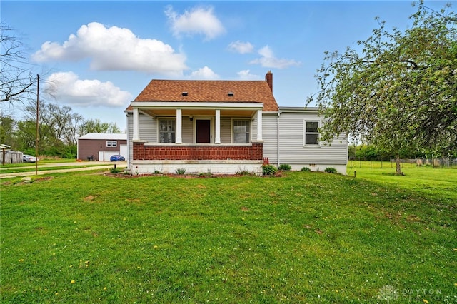 view of front facade with brick siding, a porch, and a front lawn