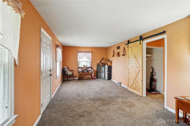 interior space featuring a barn door, visible vents, and baseboards