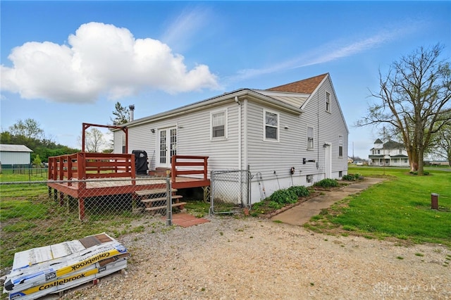 back of property featuring a lawn, a deck, french doors, and fence