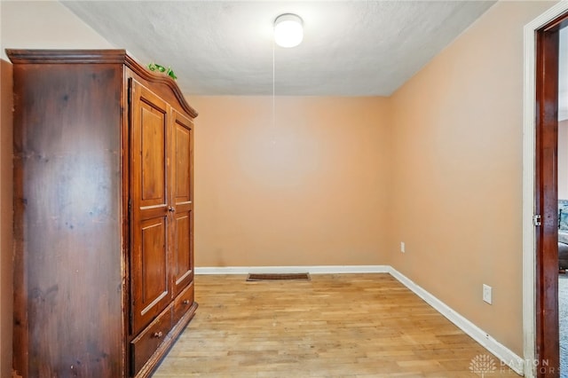 empty room with light wood-style flooring and baseboards