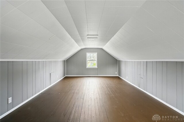 additional living space featuring lofted ceiling, baseboards, and wood-type flooring