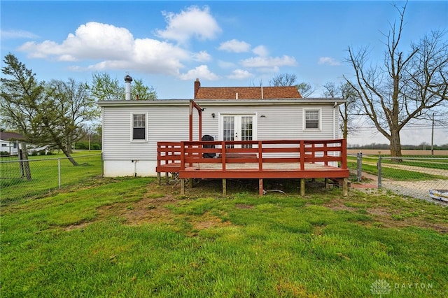 back of house with a deck, a chimney, a yard, fence, and french doors