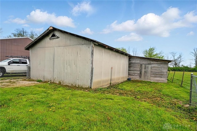 view of pole building with fence and a lawn