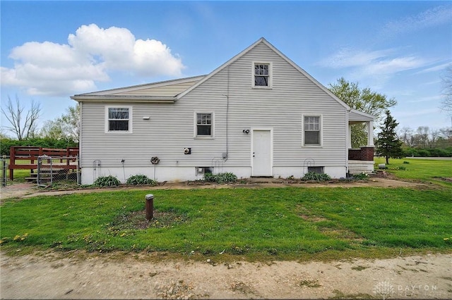 back of house featuring a lawn and fence