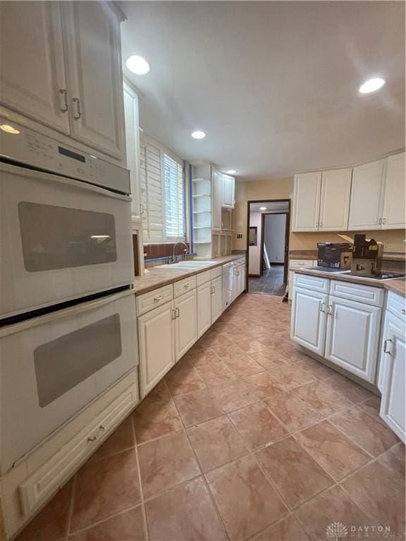 kitchen with white cabinetry, white appliances, and recessed lighting