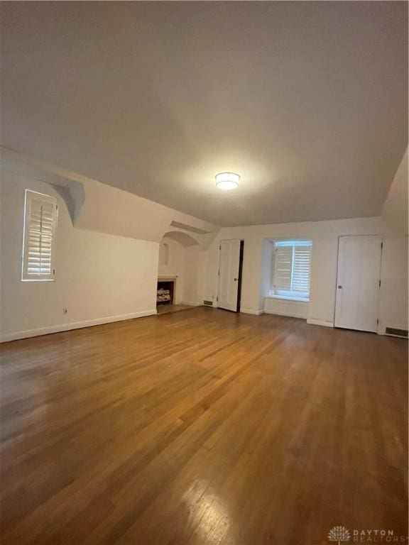 additional living space featuring lofted ceiling, wood finished floors, and baseboards