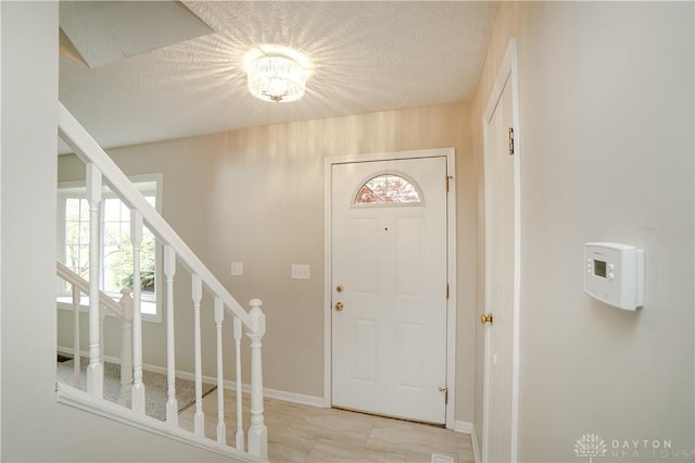 8500 Crestmont Dr, West Chester, OH 45069 - entryway with healthy amount of natural light, stairs, and a textured ceiling