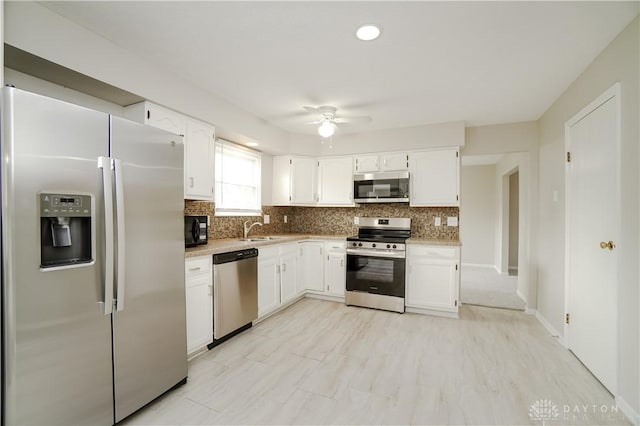8500 Crestmont Dr, West Chester, OH 45069 - kitchen featuring appliances with stainless steel finishes, decorative backsplash, ceiling fan, and white cabinetry