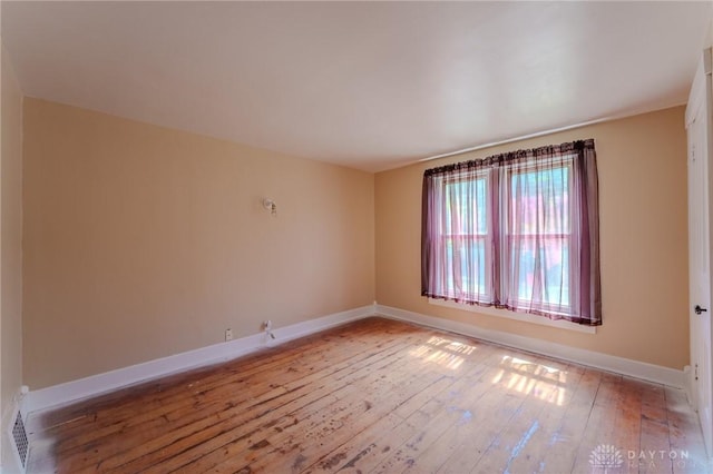 empty room with hardwood / wood-style floors and baseboards