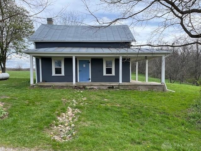 3668 Concord Fairhaven Rd, Eaton, OH 45320 - view of front facade with covered porch, a chimney, a front yard, and metal roof