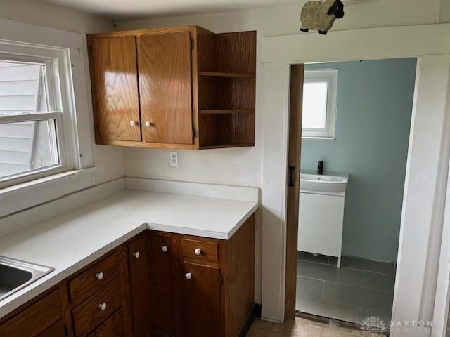 3668 Concord Fairhaven Rd, Eaton, OH 45320 - kitchen featuring open shelves, light countertops, brown cabinets, and a sink