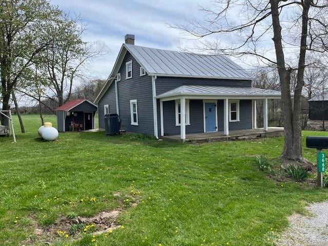 3668 Concord Fairhaven Rd, Eaton, OH 45320 - view of front facade featuring a porch, a chimney, a front lawn, and metal roof