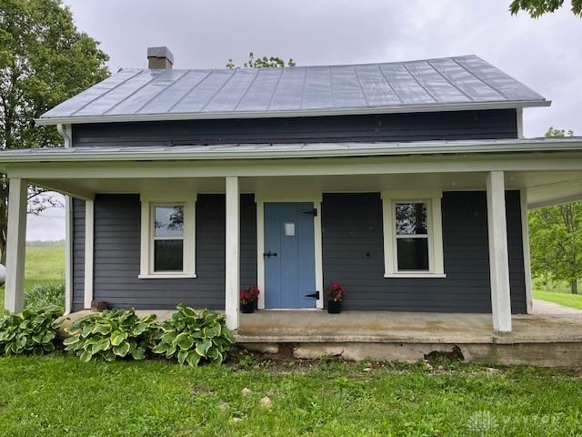 3668 Concord Fairhaven Rd, Eaton, OH 45320 - view of front of home with a porch, a standing seam roof, metal roof, and solar panels