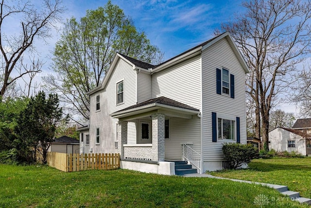 traditional-style house with a front lawn and fence