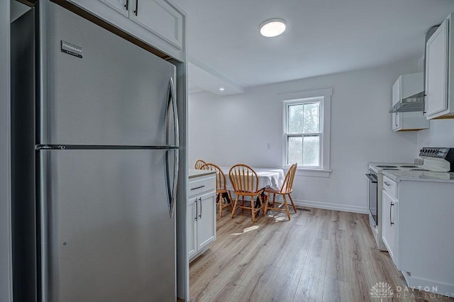 kitchen featuring light wood-type flooring, white cabinetry, light countertops, freestanding refrigerator, and electric range