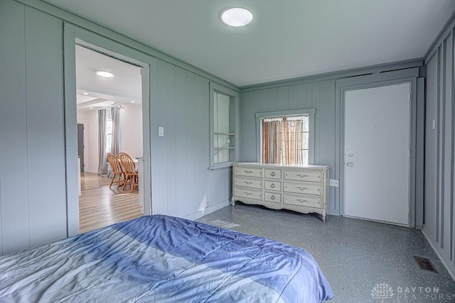 bedroom with a decorative wall and visible vents