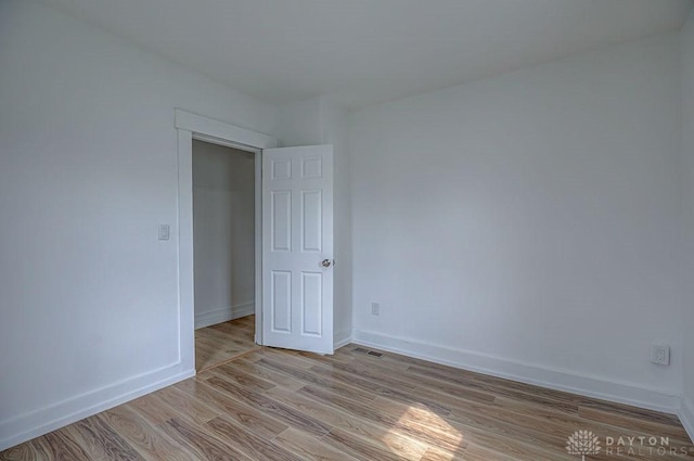 spare room with baseboards, visible vents, and light wood-style flooring