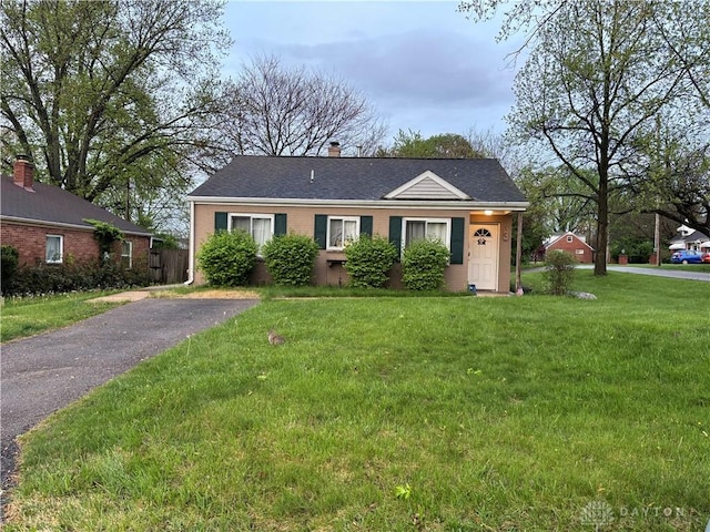 bungalow-style home with a front lawn, brick siding, and a chimney