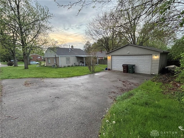 exterior space featuring an outdoor structure, a detached garage, and a yard