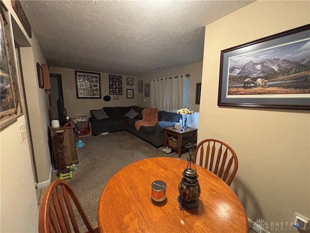 dining room featuring a textured ceiling and carpet flooring