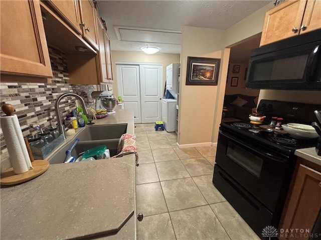 kitchen featuring a sink, brown cabinets, light tile patterned floors, tasteful backsplash, and black appliances