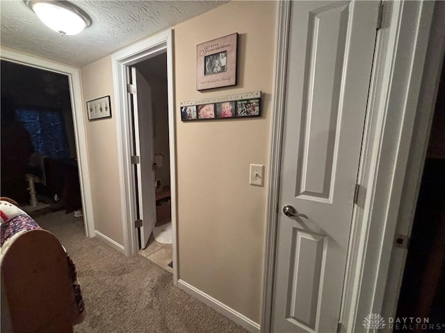 hallway with light carpet and baseboards