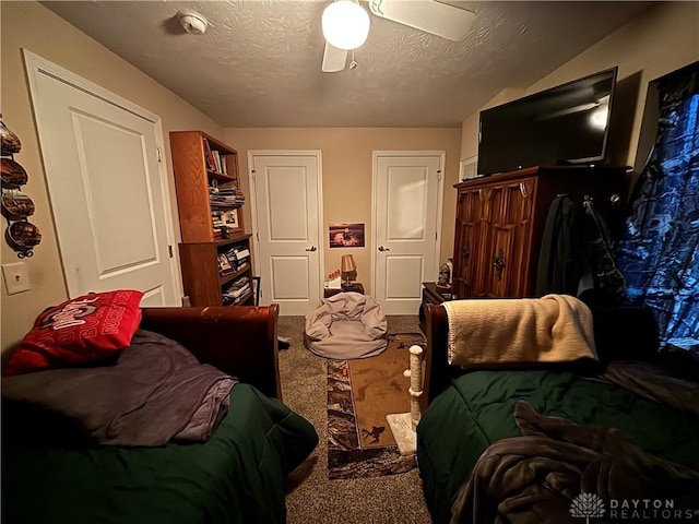 bedroom featuring a textured ceiling, a ceiling fan, and carpet floors