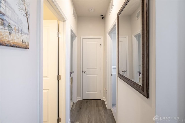 corridor with visible vents and wood finished floors