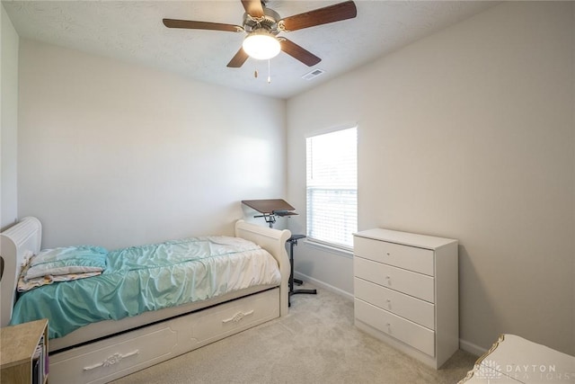 bedroom with baseboards, visible vents, ceiling fan, and light colored carpet
