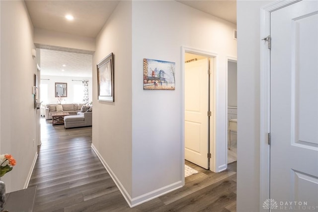 hall with recessed lighting, dark wood finished floors, and baseboards