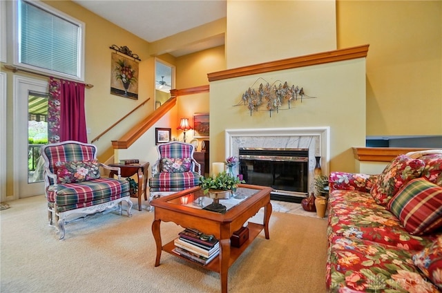 living area with stairway, a premium fireplace, and carpet flooring